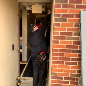 Locksmith prepares an opening for a commercial door installation in Ashville, NC