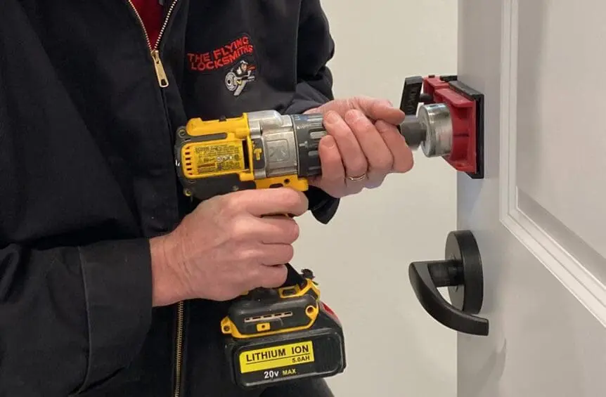 Access control technician preps door for keyless deadbolt lock
