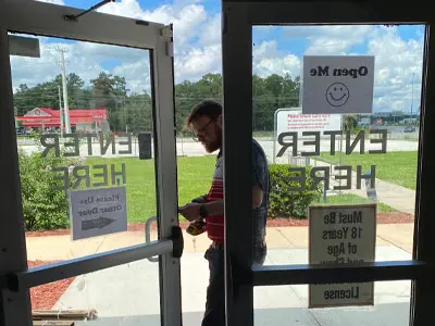 Technician installs a glass storefront door for a local business