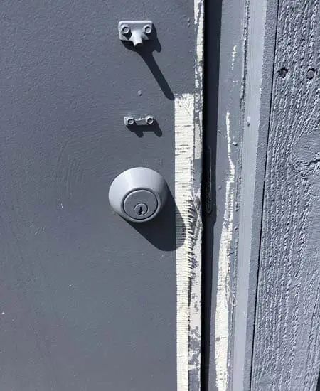Image three of damaged hardware on an ugly door