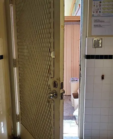 Image two of damaged hardware on an ugly door