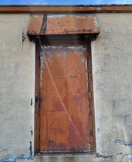 Image one of rust and light showing through an ugly door