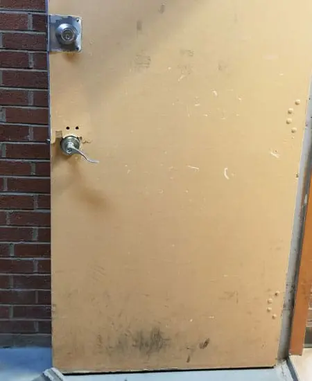Image one of damaged hardware on an ugly door