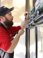 AAADM certified technician adjusts automatic door operator to be ADA compliant
