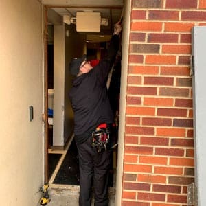 Locksmith prepares an opening for a commercial door installation in Ashville, NC