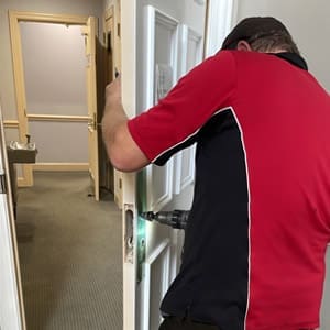 Locksmith service technician prepares door for hardware installation