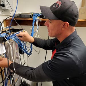 Security Technician Plugs Cat6 Cable Into a Camera System Server