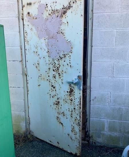 Commercial metal door with rust damage