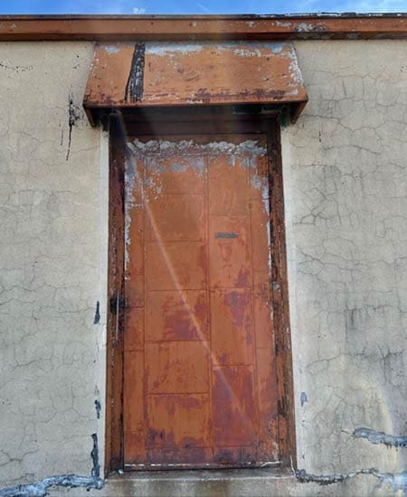 Image one of rust and light showing through an ugly door