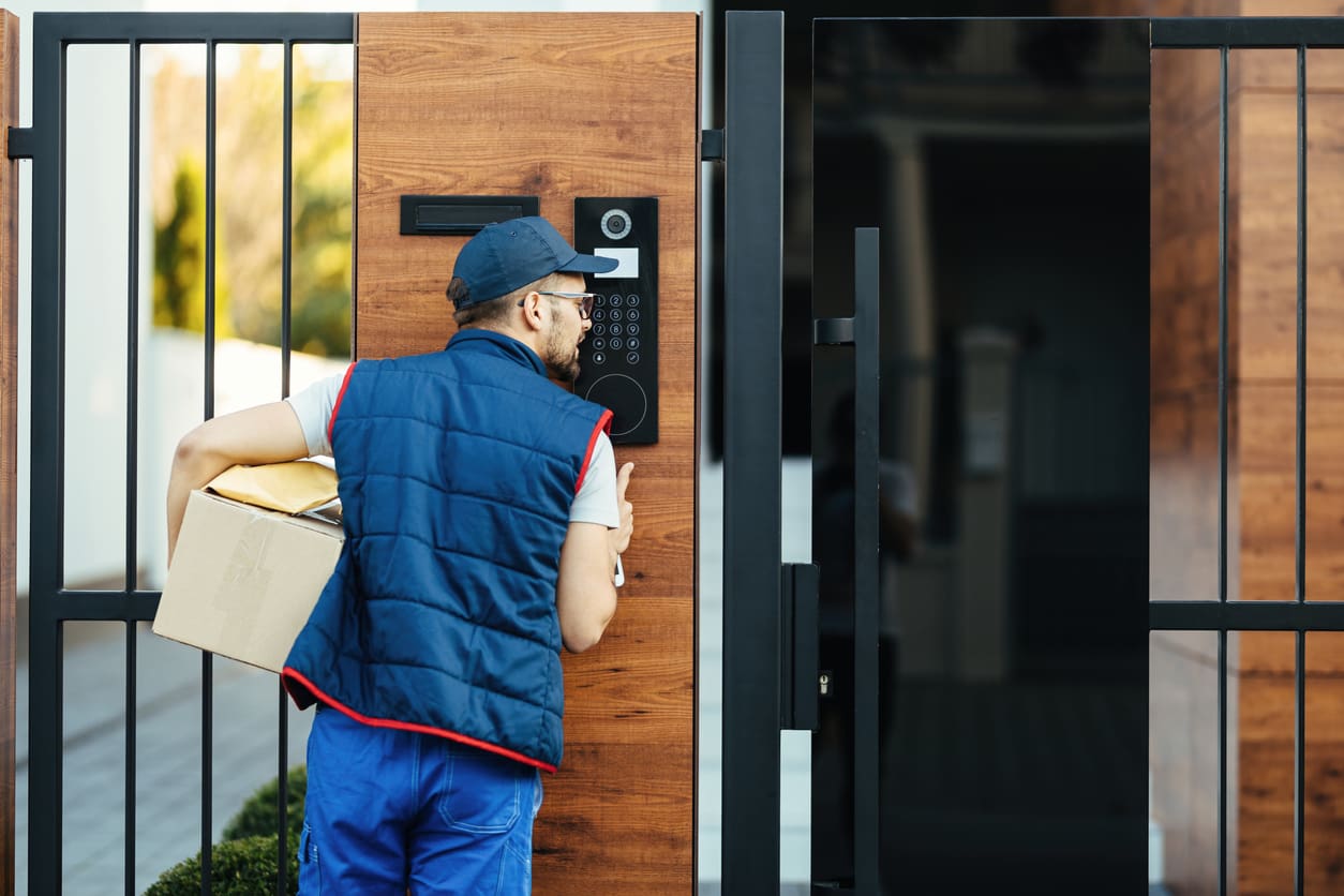 Package delivery man using a video enabled intercom system at a commercial facility.